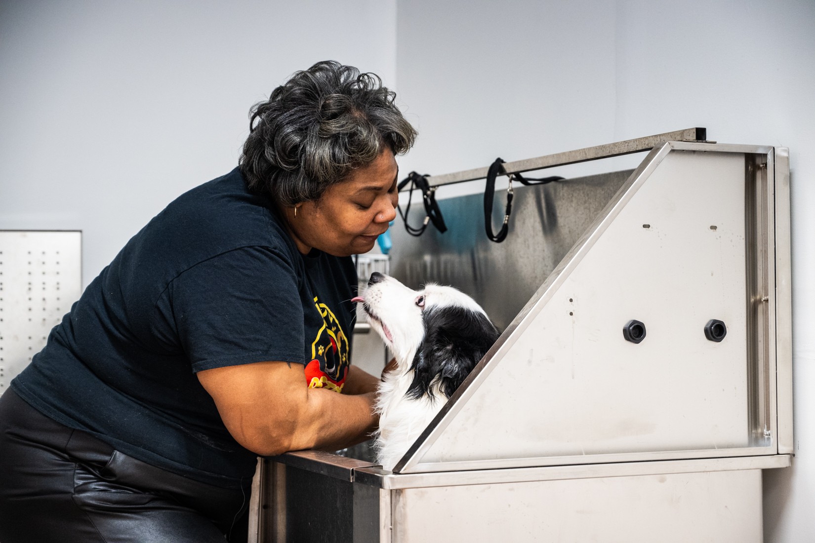 Owner Amanda Daniels cleans Moochy the dog at Lucky’s Pet Store in Bronzeville, providing expert grooming services.