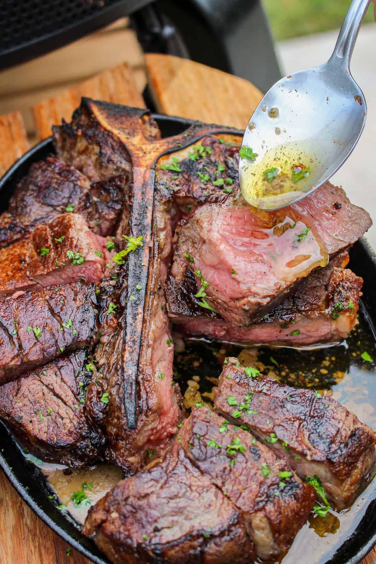 Coarse sea salt being sprinkled onto a raw steak