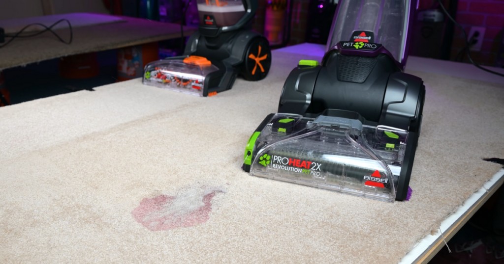 Bissell 2X Revolution Pet Pro using &quot;Clean Shot&quot; technology to target a stain, ideal for pet owners needing to pretreat pet stains effectively.