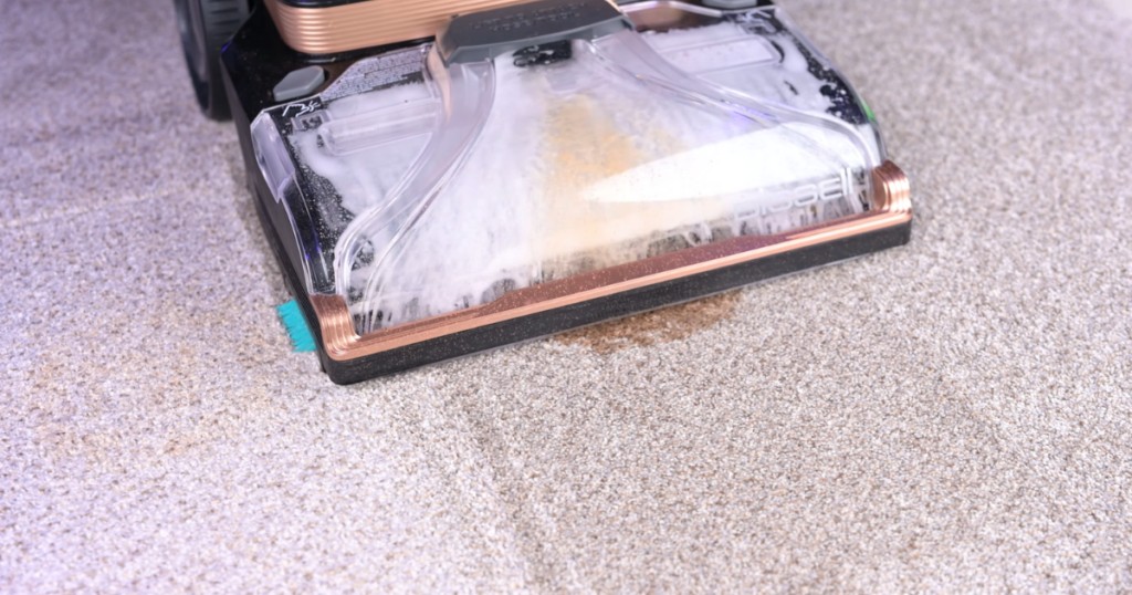 A carpet shampooer effectively cleaning a pet stain on a carpet, visibly lifting the stain and cleaning the carpet fibers, demonstrating stain removal performance critical for pet owners.