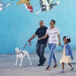 A happy family enjoys quality time with their Dalmatian dog at a park in Knoxville, Tennessee.