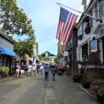 A charming street view in Newport Rhode Island, showcasing historic buildings and a glimpse of the ocean, capturing the essence of a pet-friendly travel destination.