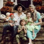 A family of five dressed in Peter Pan themed costumes for Halloween. The family includes Peter Pan, Wendy, Captain Hook, Tinker Bell, and Mr. Smee.