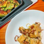 A close-up shot of Taleggio Agnolotti pasta dish at Il Ritorno downtown st pete dining, showcasing tender pasta, lamb belly, charred leeks, and chive oil