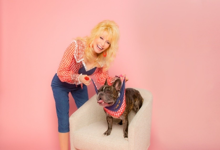 Dolly Parton smiling and wearing a denim jacket