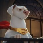 Krypto the Super-Dog, a white dog wearing a red cape and collar, standing heroically.