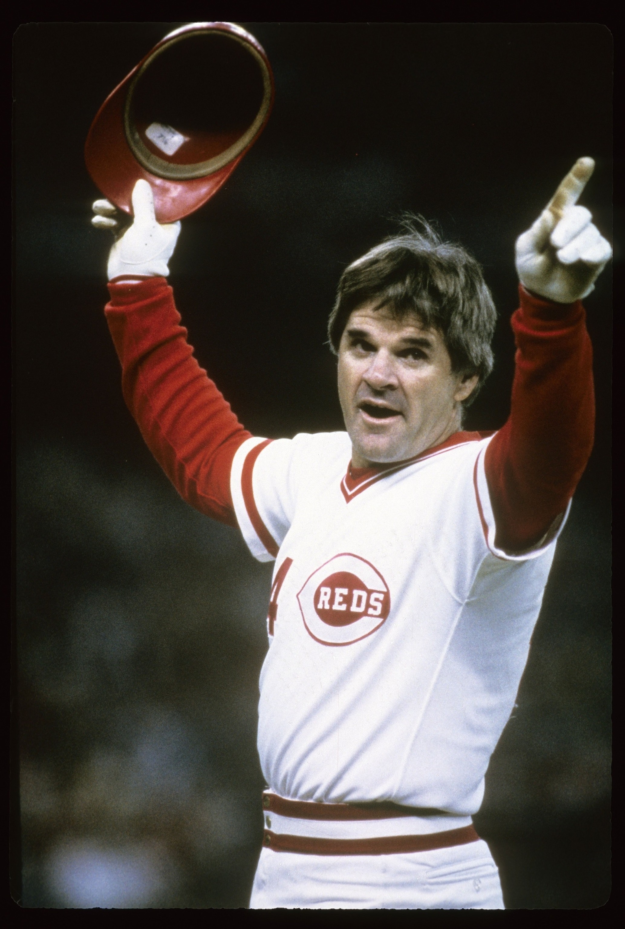 Pete Rose salutes the crowd after breaking Ty Cobb's hit record, showcasing his connection with fans.