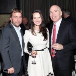 Peter Billingsley, Buffy Bains, and David Barr smiling holding champagne glasses at a gala