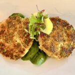 Close-up of golden brown and crispy blue crab cakes, showcasing the texture and appetizing presentation, an excellent starter at waterfront St Pete Beach restaurants.