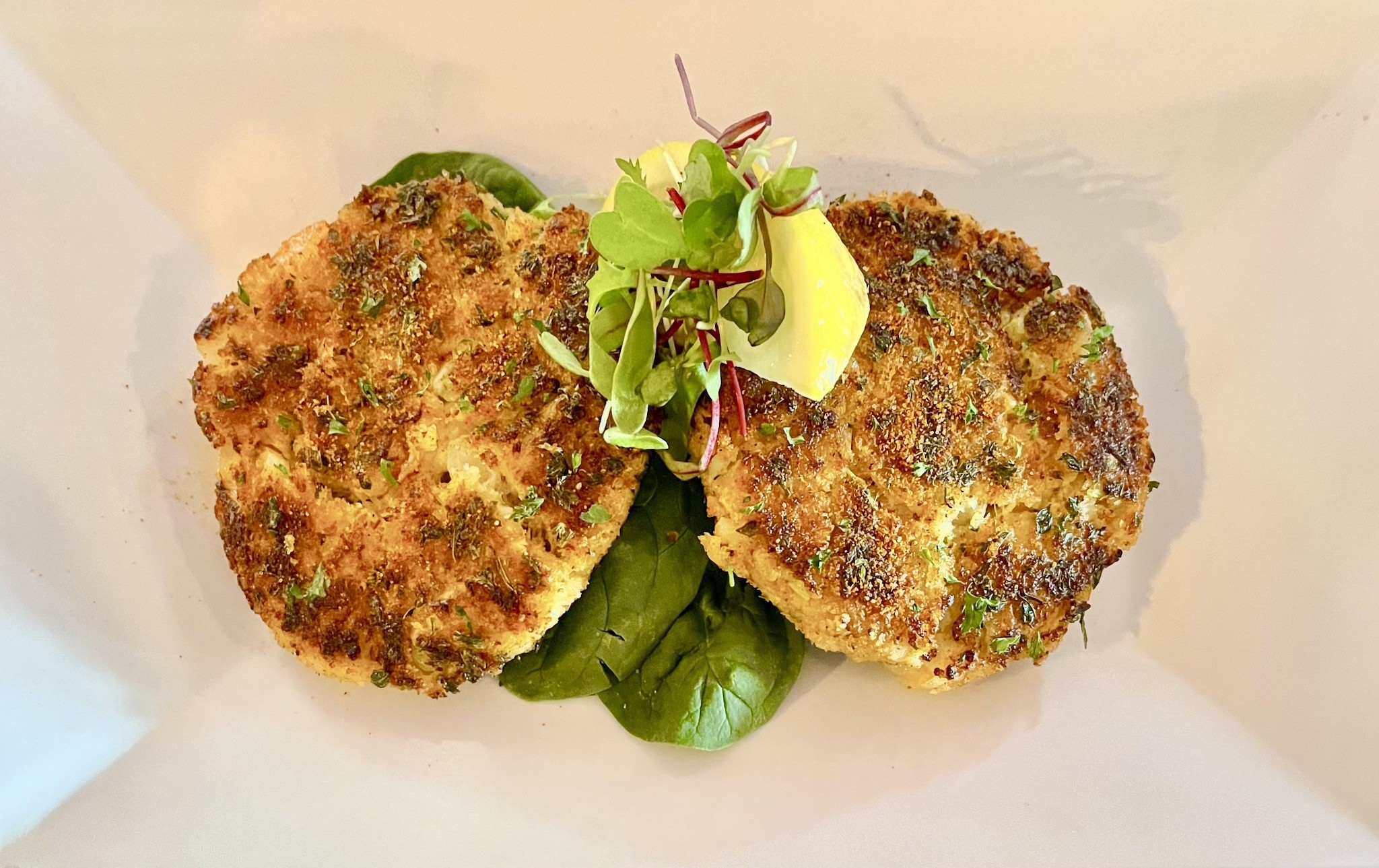 Close-up of golden brown and crispy blue crab cakes, showcasing the texture and appetizing presentation, an excellent starter at waterfront St Pete Beach restaurants.