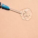 Thin needle in a transparent gel-like liquid with bubbles on a beige background