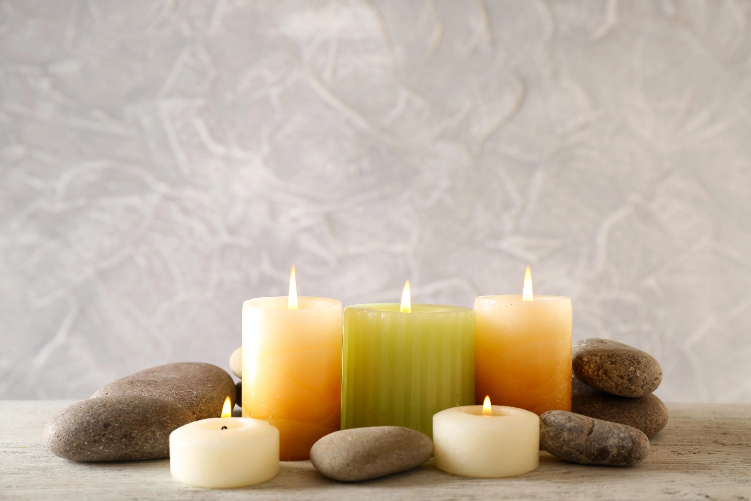 Still life with spa candles on light wallpaper background