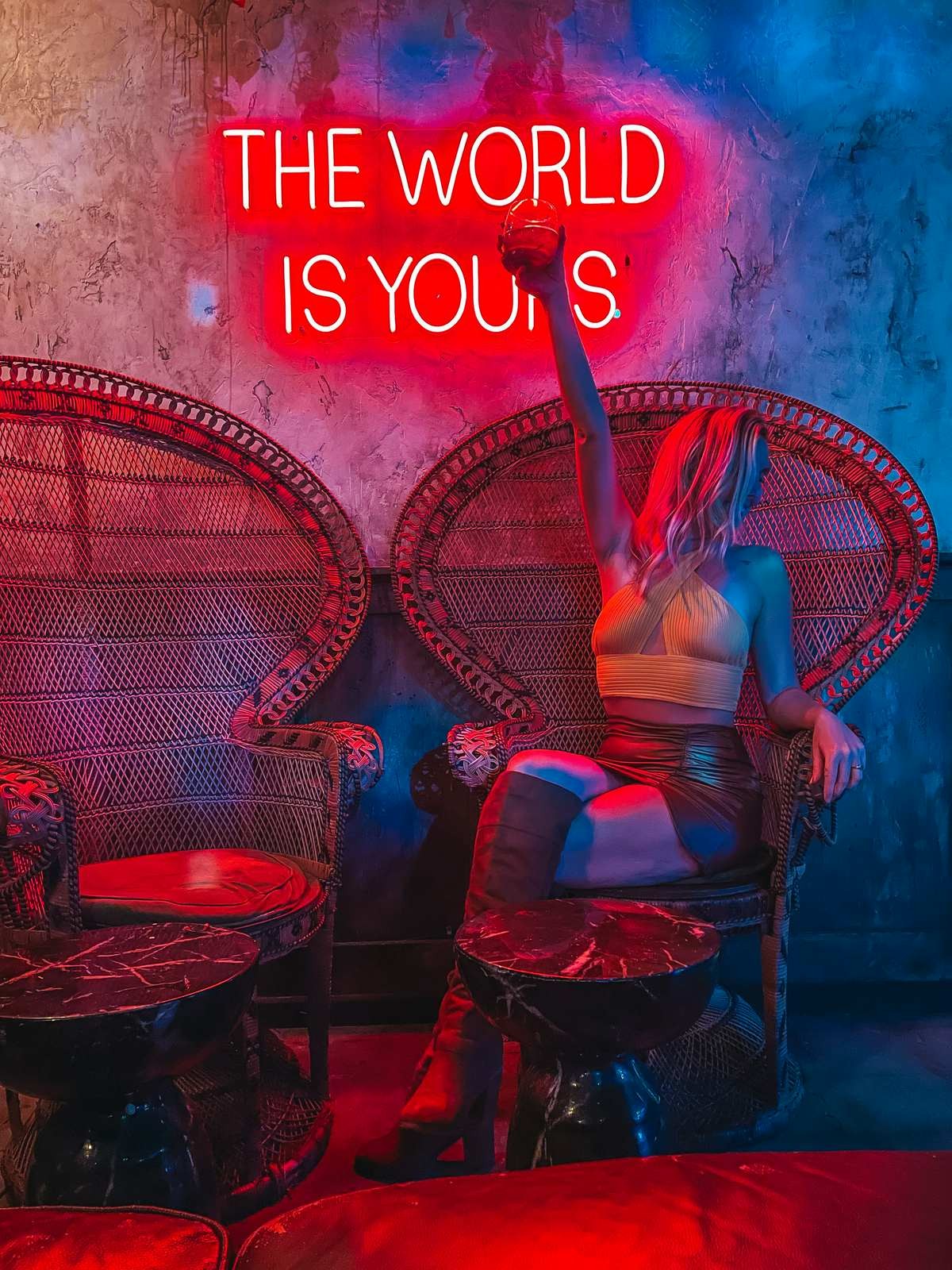 Woman holding up a cocktail at Dirty Laundry bar in St Pete with showcases a vibrant and unique ambiance.
