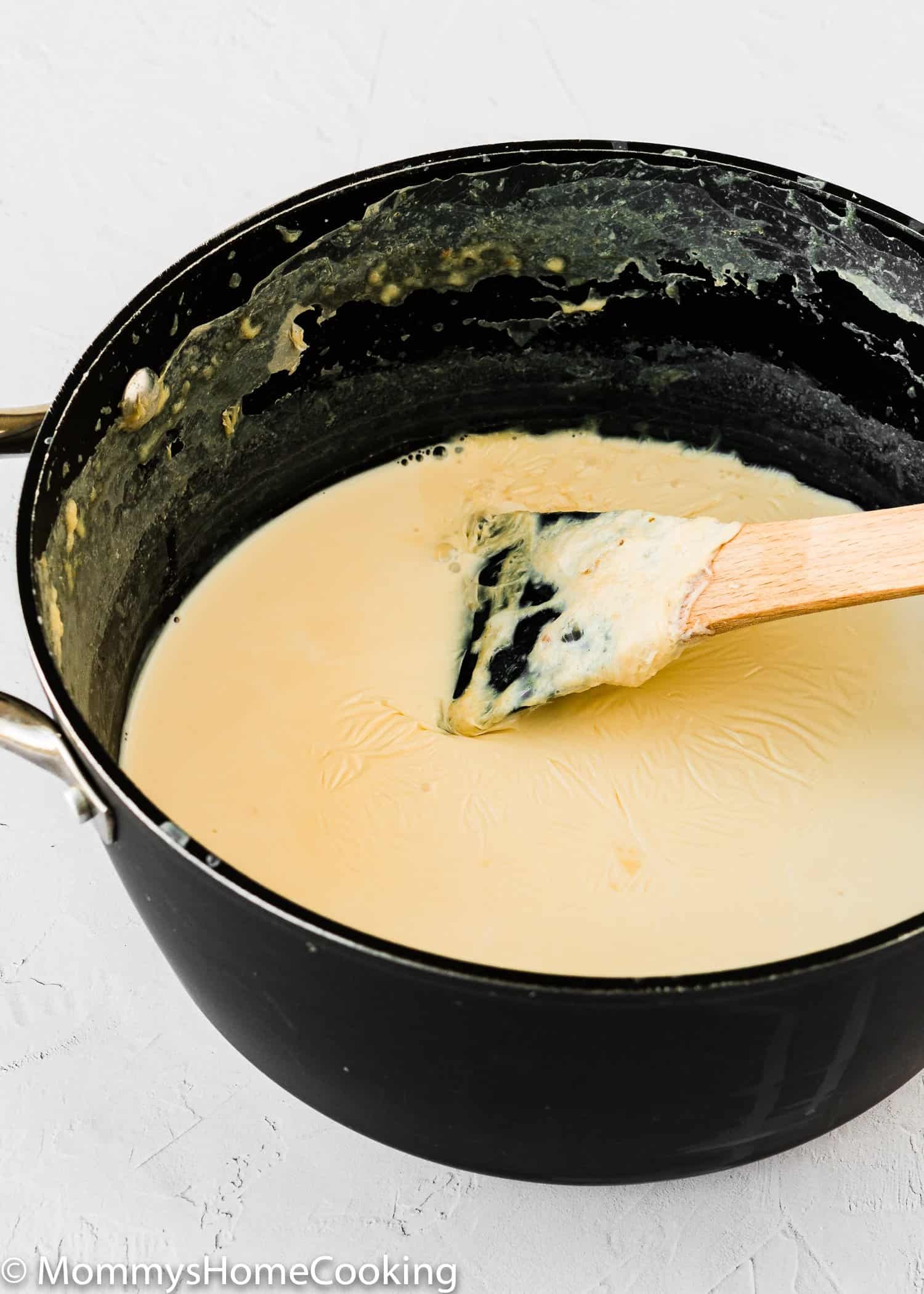 Warming homemade pet milk in a pot on the stove.