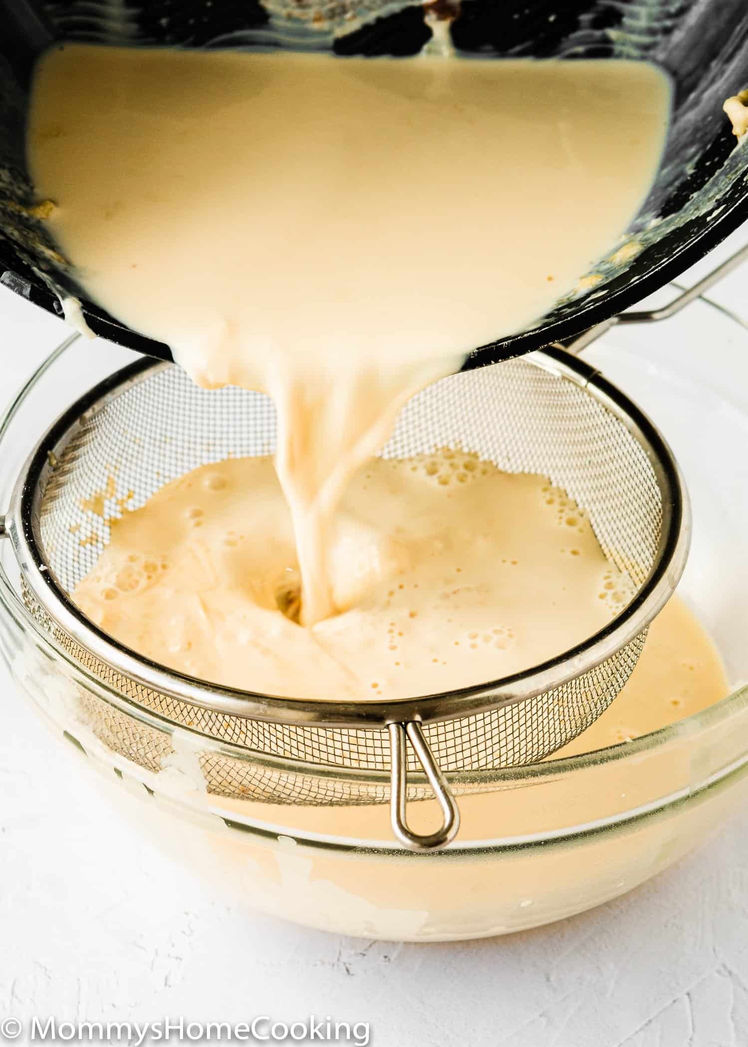 Homemade pet milk being strained through a sieve.