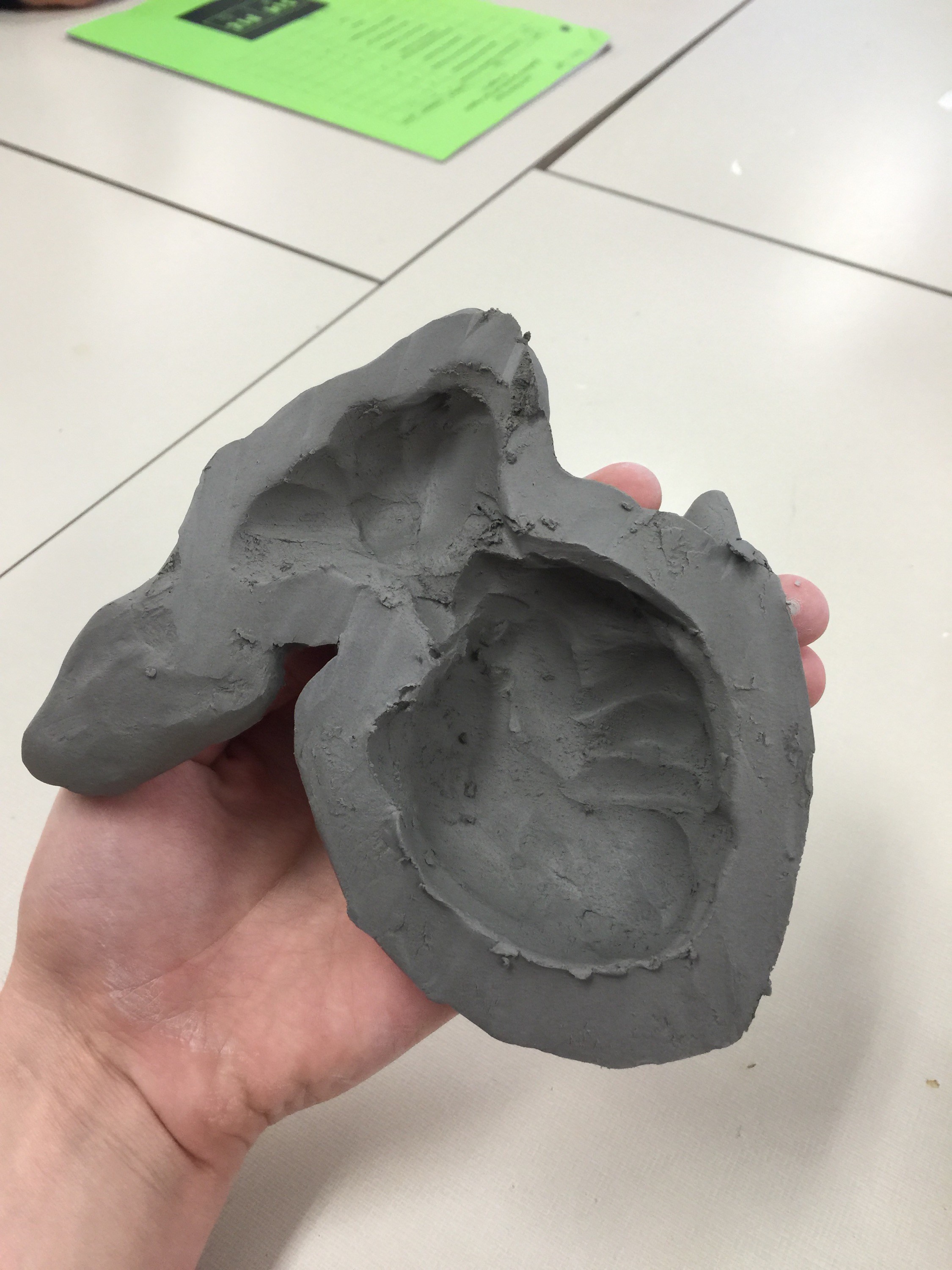 Clay animal halves prepared for rejoining, highlighting hollowing process