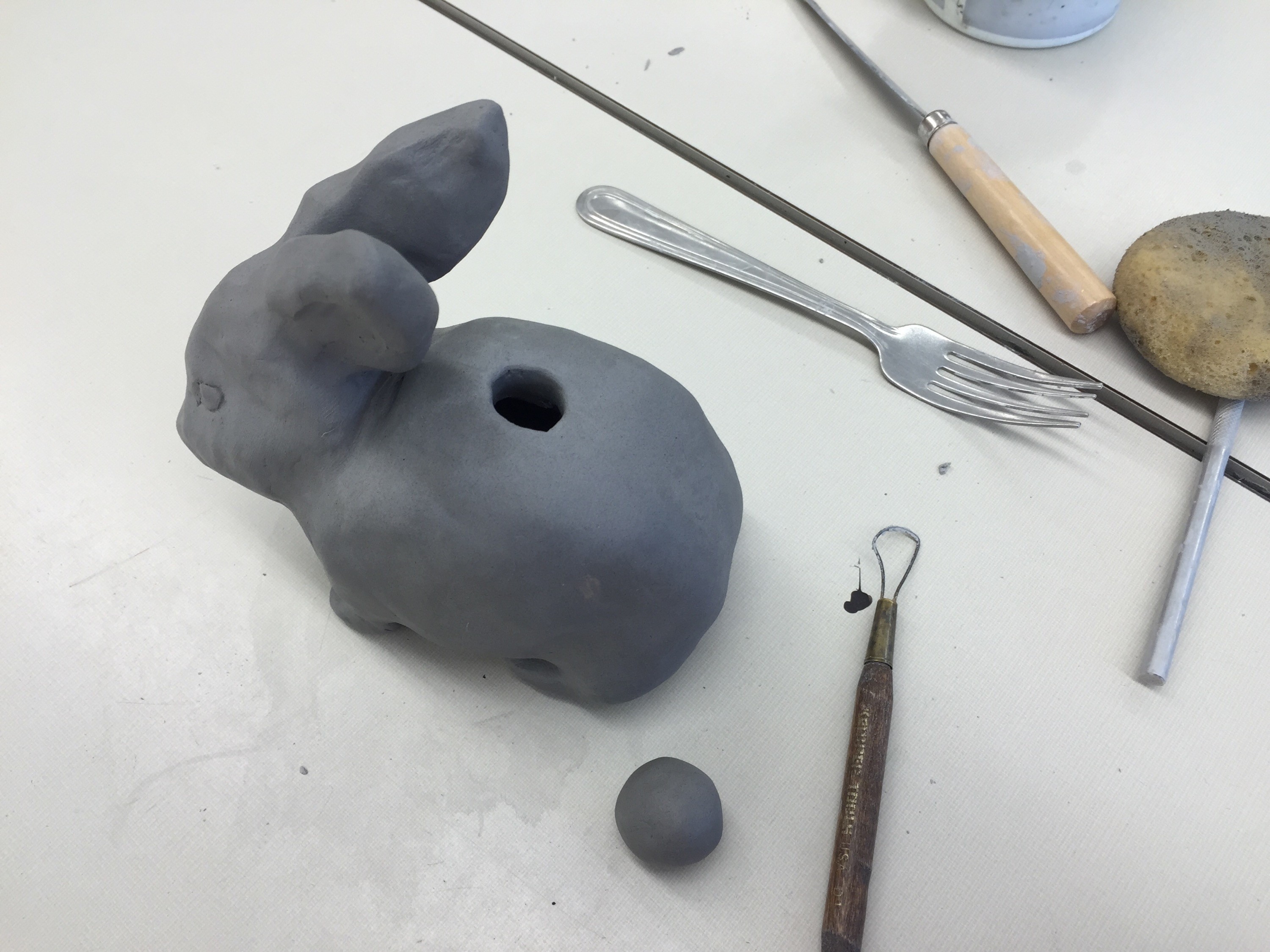 Clay animal halves scored and slipped together, ready for drying