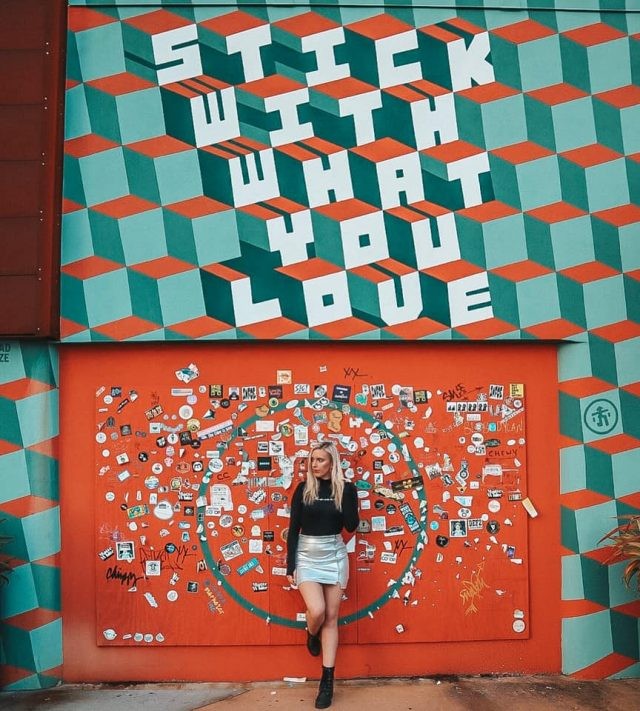 In front of a mural that says